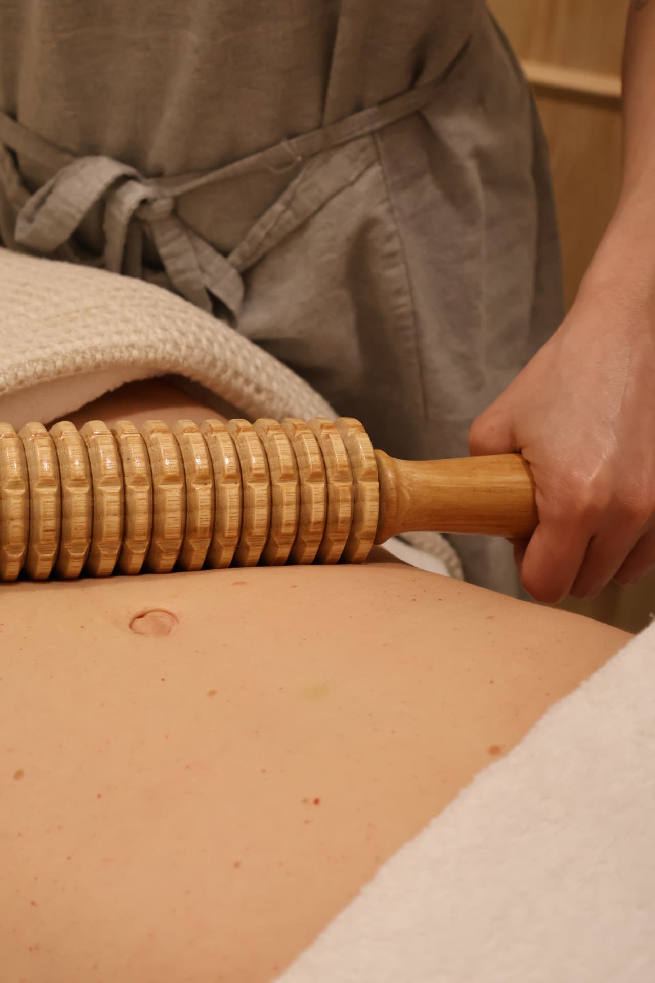 Maderoterapia corporal con rodillo de madera en abdomen